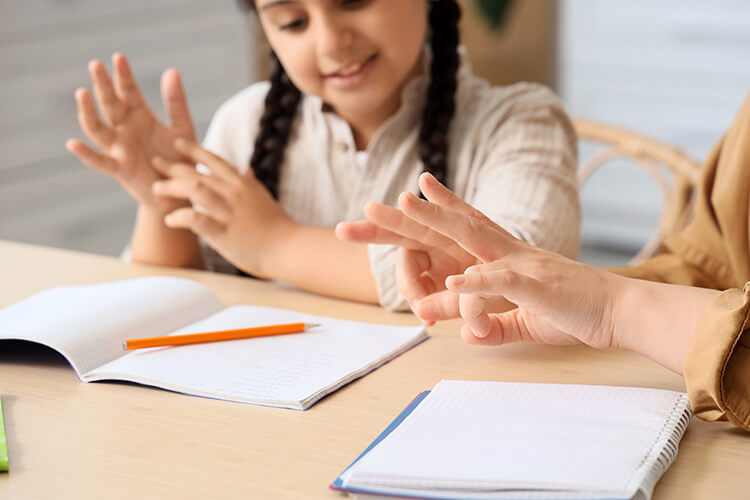 An interpreter working through a lesson in sign language with a young student